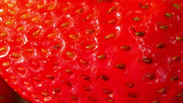 Close-up view of a fresh strawberry emphasizes intricate details and vivid color, supporting concepts of wellness, freshness, productivity, sustainability, and natural perfection. 4k.
