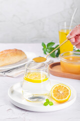 Fototapeta premium Crystallized Honey and Lemon Water with Fresh Flowers and Mint