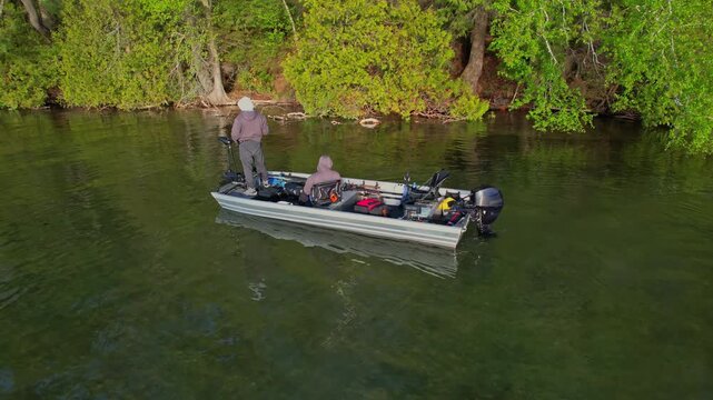 Beautiful lake Couchiching in Orillia Ontario Canada north of Simcoe Lake. Bass season opener. Motor boat with fishermen on water. Aerial view shot. Fishing boat and two anglers enjoying leisure.