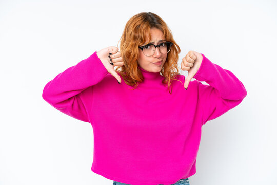 Young caucasian woman isolated on white background showing thumb down with two hands