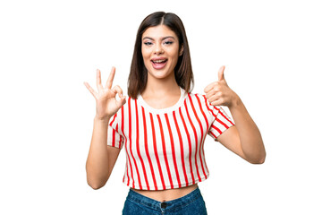Obraz premium Young Russian woman over isolated chroma key background showing ok sign and thumb up gesture