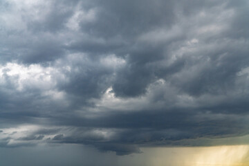 Obraz premium Summer storm clouds before a thunderstorm. Dark storm clouds before the rain. Bad weather. A heavenly landscape of clouds in the sky on a rainy day. Majestic cumulus clouds float across the sky. 