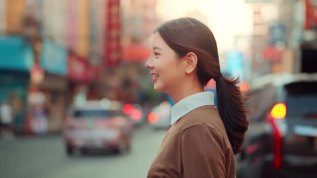 Side view of happy Asian woman smiling and walking on city street at Chinatown Bangkok, beautiful young female traveler exploring local food stalls and shops during evening holiday for tourism