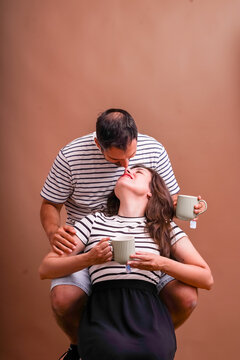 Couple sharing tender kiss drinking hot tea