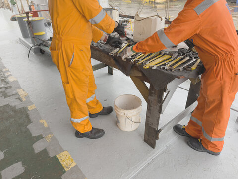 old bosun teach young ordinary seaman for use tools and maintenance the ship