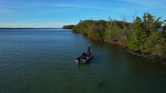 Beautiful lake Couchiching in Orillia Ontario Canada north of Simcoe Lake. Bass season opener. Motor boat with fishermen on water. Aerial view shot. Fishing boat and two anglers enjoying leisure.