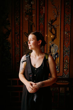 Woman stands in a decorated room and looks towards the side