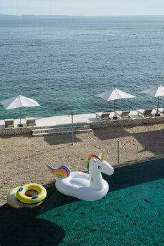 Inflatable Unicorn Float in a Tropical Pool by the Sea