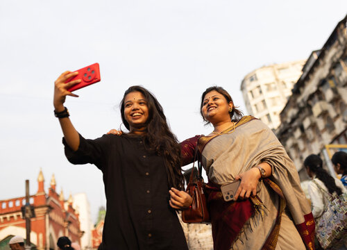 Mother and daughter thing selfie at outdoors in a metropolitan city