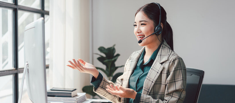 Smiling Asian Woman Telemarketing Agent with Headset Working at