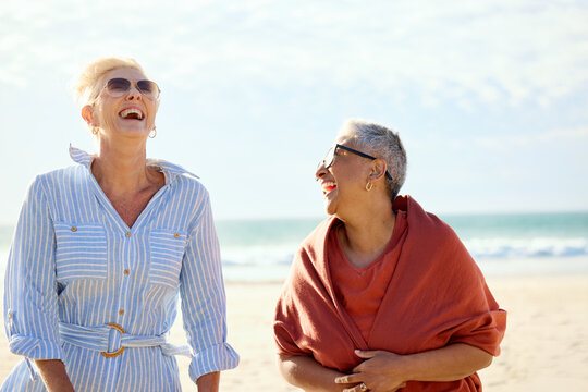 Two Women Laugh Together on the Beach