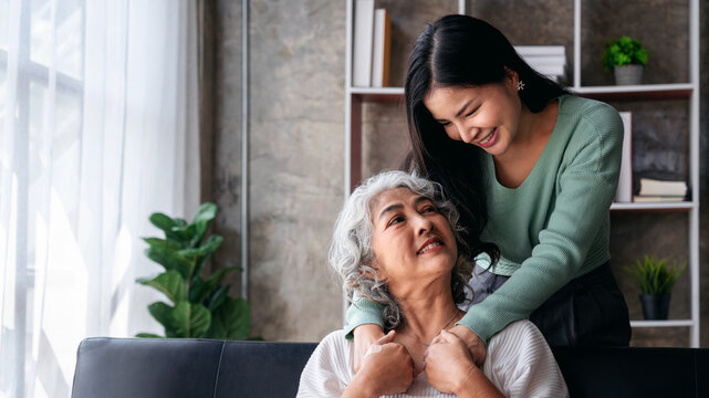 Asian Adult Daughter Giving an Older Mother a Gentle Hug Showing
