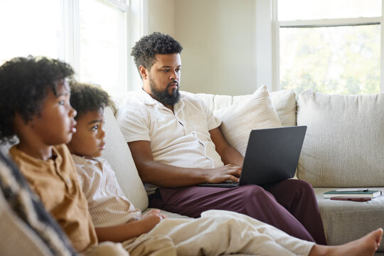 Dad Uses Laptop at Home With Kids