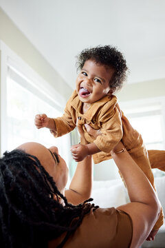 Mother Plays in Home With Baby in the Air