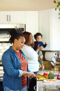 Family Members Cook Together in Home Kitchen