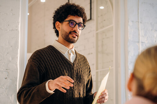 A man is talking while standing indoors