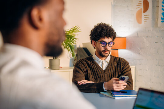 A man uses a mobile phone during an office meeting