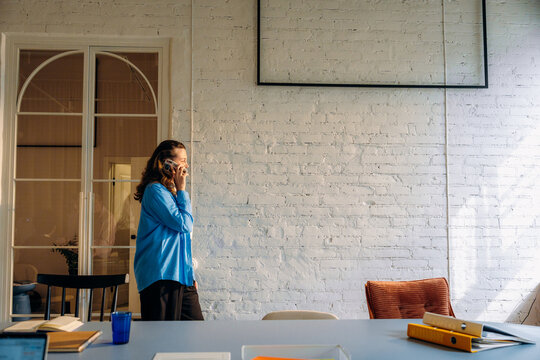 A woman is talking on a mobile phone in the office