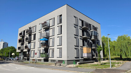 Modern cubical apartment block with grey concrete facade and small balconies © hecos
