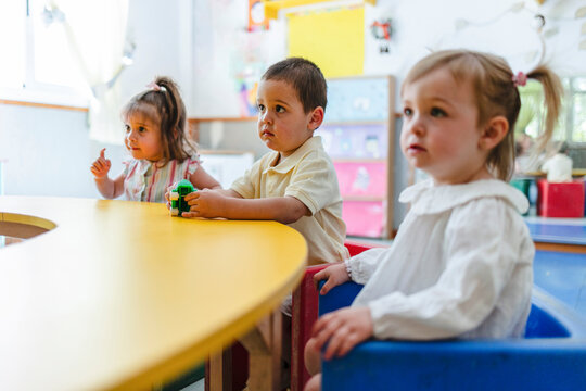 Young children attentively learning during preschool class activities