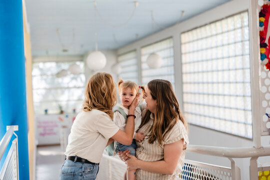 Loving women caring for a happy toddler girl