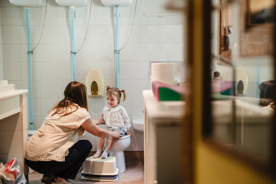 Mother helping young child with toilet training