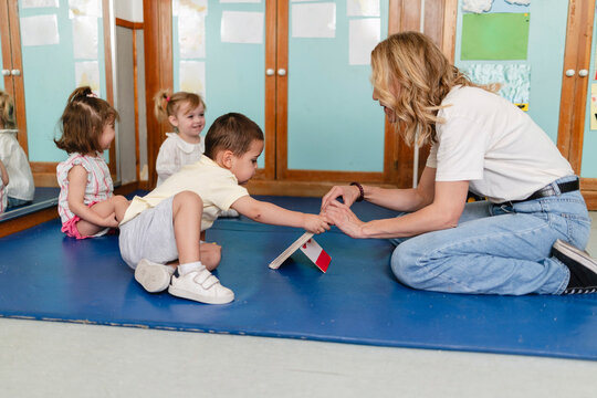 Teacher guiding small boy learning about flags