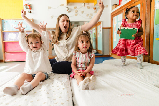 Teacher and toddlers playing and having fun in nursery school