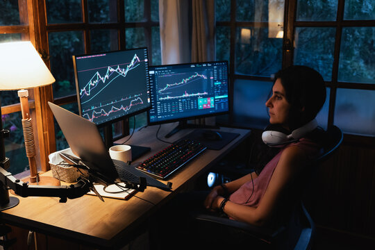 woman Trading and analysing financial Stock charts on Multiple Screens