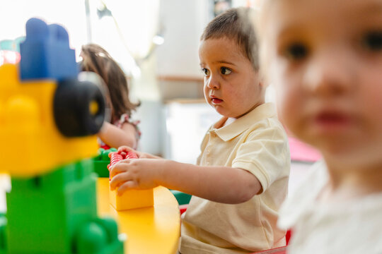 Young boy concentrating playing with colorful building blocks