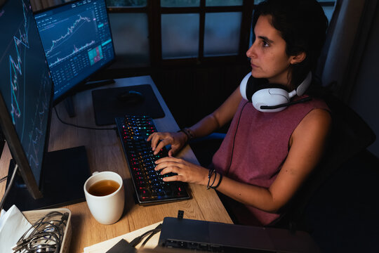 woman Trading and analysing financial Stock charts on Multiple Screens