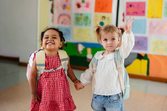 Diverse toddlers holding hands starting school