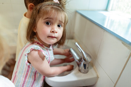 Toddler girl washing hands learning good hygiene habits