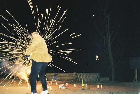 Young Man Surrounded by Fireworks During Lunar New Year