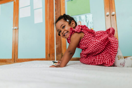 Happy little girl smiling and playing indoors