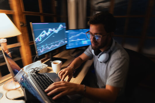 trader Analyzing Stock Charts on Multiple Screens at Night