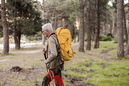 Senior man enjoying active hiking in forest