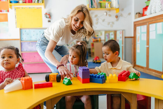 Teacher engaging with children playing building blocks