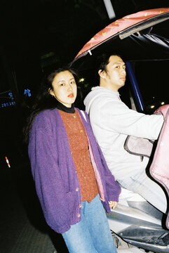 Stylish Young Couple on Electric Scooter at Night in China
