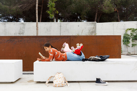 Girl using smartphon While Lying on a Bench