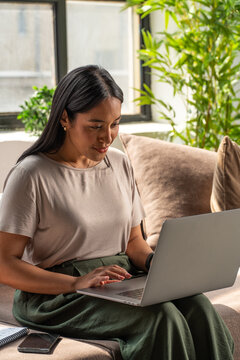 Woman Working Remotely on Laptop in Comfortable Workplace