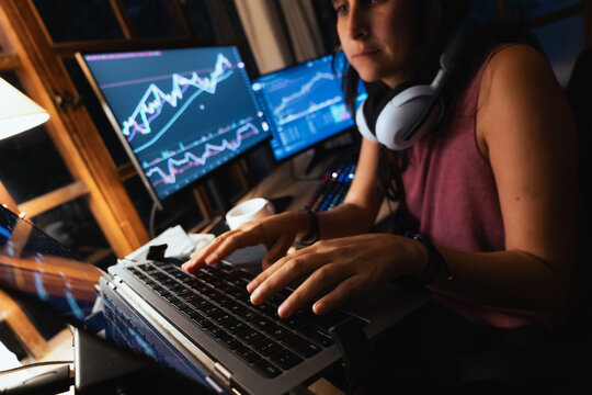 woman Trading and analysing financial Stock charts on Multiple Screens