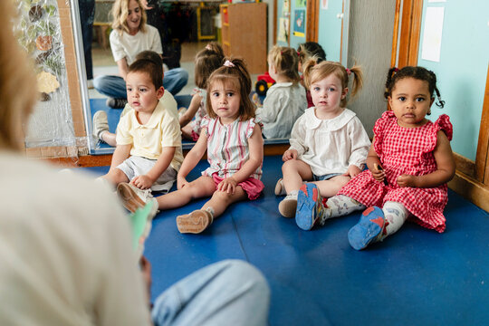 Diverse preschoolers attentively learning in group at kindergarten
