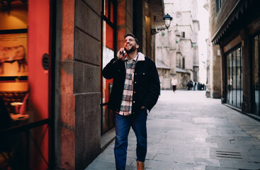 Thoughtful man with beard leaning on hands looking away, male in jacket feeling tired or bored, authentic person emotional state, urban cafe setting, profile portrait, copy space. © BullRun