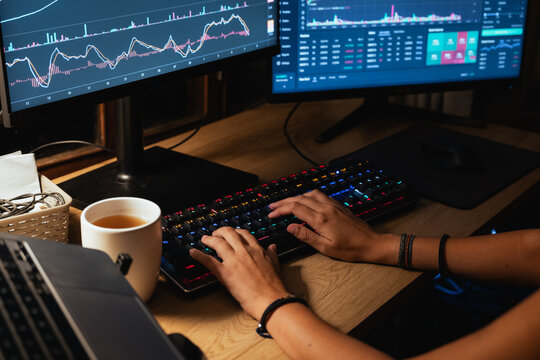 Trader hands working with Stock chart on Multiple Screens