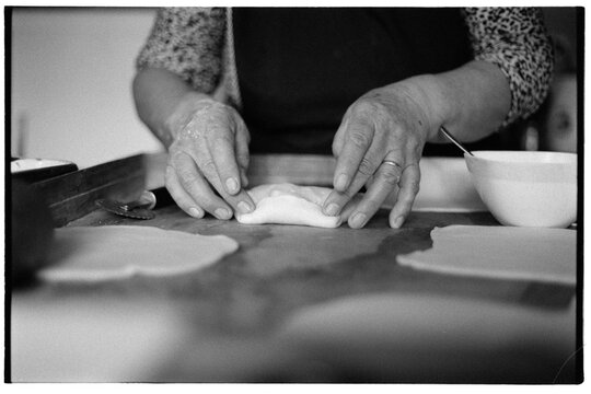 Hands folding dough for empanada