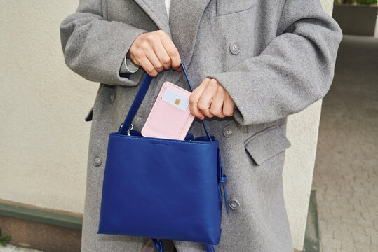 Woman places credit card in blue bag 