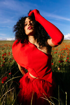 Woman in red fashion outfit in poppy field