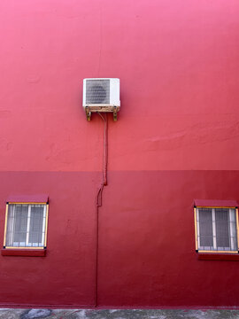 Air Conditioning Unit On Pink Building Wall