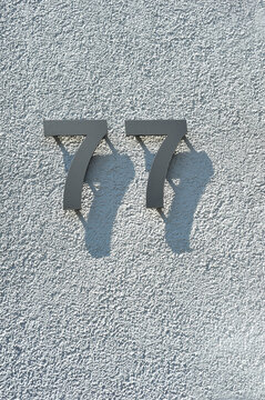 77 Hausnummer mit Schatten
